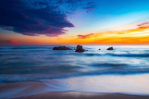 Calming sunrise over the ocean with rocks and harmonious colors in the sky, sunset, Praia do Amado,