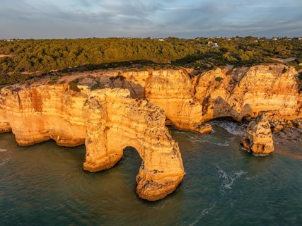 Drone view of Praia da Marinha beach in Algarve, Portugal, with golden cliffs, sea arches,