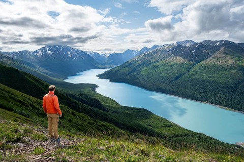 Mountaineer enjoys views of blue lake and mountains on Twin Peaks Trail, Eklutna Lake, Chugach