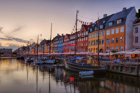 Abend in einem historischen Hafen mit traditionellen Häusern und Booten im Wasser, Kopenhagen,