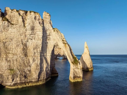 Aerial view of the Porte d'Aval rock formation with the free-standing Aiguille d'Étretat rock pin