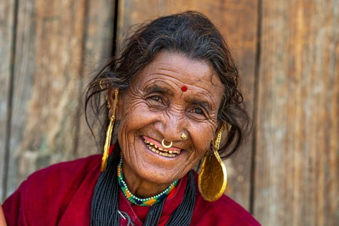 Portrait, friendly smiling elderly woman with traditional jewelry and bindi, Hindu ethnic group,