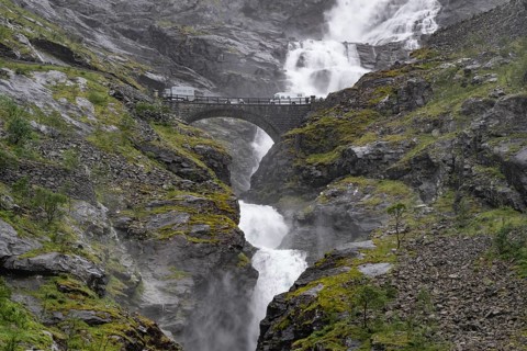 Motorhome on a bridge in front of heavily swollen Stigfossen waterfall, Trollstigen, near Åndalsnes