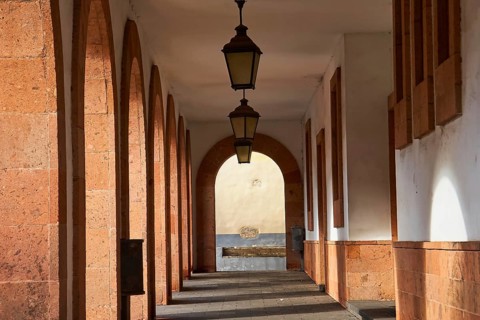 Pergola with red arcades and old lanterns, historic atmosphere with quiet shadows, UNESCO World