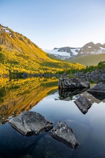 Picturesque mountain landscape in the Innerdalen high valley, mountain peaks reflected in Lake