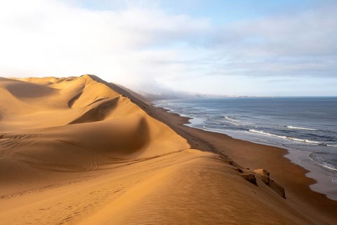 Sand dunes and sea with coastal fog in the morning, Atlantic coast and sandy desert with sea of