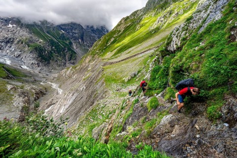 Mountaineers on a hiking trail, dramatic mountain landscape with Grindelwald-Fiescherfirn glacier,