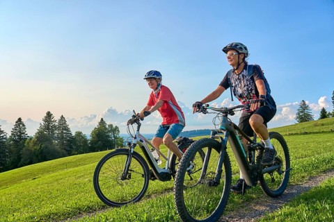 Two senior girlfriends have fun during a e-bike cycling tour in the Allgau Alps near Oberstaufen,