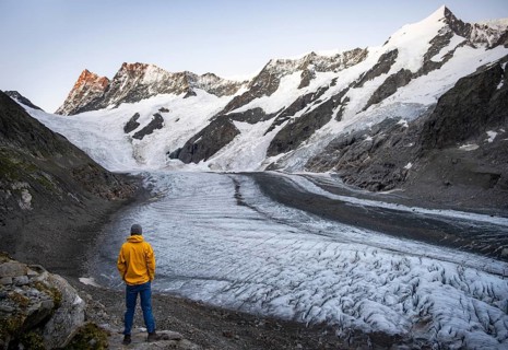Young man in front of impressive high-alpine landscape, Finsteraarhorn and Agassizhorn mountain