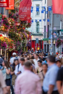 Busy street with crowds, colorful hanging baskets and banners, Dublin, Ireland