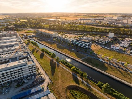Urban landscape with office buildings and canal in warm sunset light, airfield, Böblingen, Germany