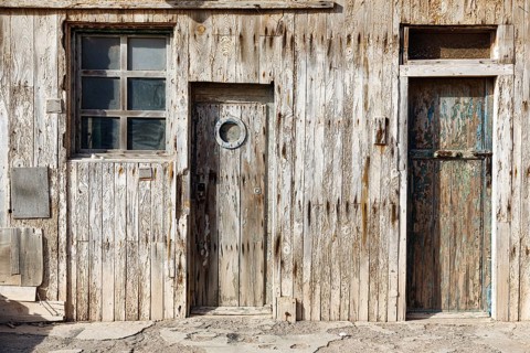 Rustic cabin with weathered wooden façade, traditional wooden coastal architecture, detail, doors