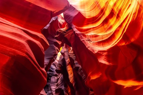 Sandstone rock walls creating a narrow slot canyon with swirling shapes and vibrant colors,