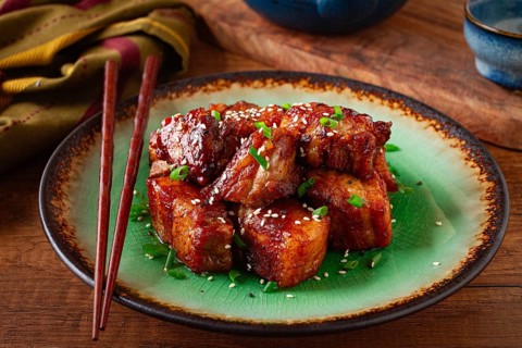 Chinese-style meat with sesame seeds and green onions, on a wooden table, homemade, no people