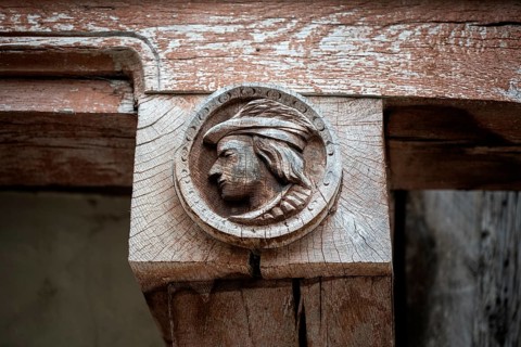 Historic wood relief, profile portrait of a man on a support beam of a historic half-timbered
