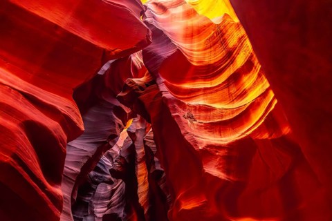 Antelope canyon slot offering a vibrant display of light and shadow on its curved sandstone walls,