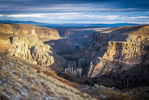 Panoramic view to Ihalra valley canyons dunring the sunrise in winter with dramatic cloudy sky.