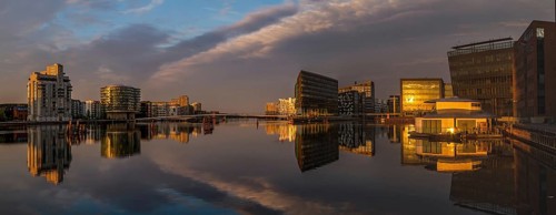 Moderne Gebäude spiegeln sich im ruhigen Wasser bei Sonnenuntergang, Kopenhagen, Dänemark