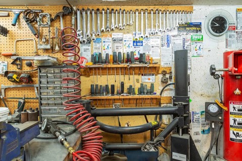 Parts drawers, various hand tools including wrenches, screwdrivers, hammer arranged on shelves and