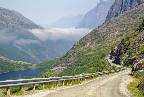A winding mountain road leads through a rocky, foggy landscape, Aursjövegen, More og Romsdal,