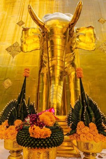 Gilded elephant statue with green and orange floral decoration in the Wat Phra Singh Buddhist