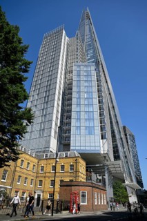 View of The Shard skyscraper, a historic brick building and a red telephone box, London Bridge,