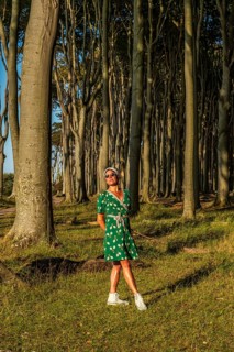 A woman (54) is standing in the Gespensterwald, Nienhagen, Germany, wearing a green tennis dress
