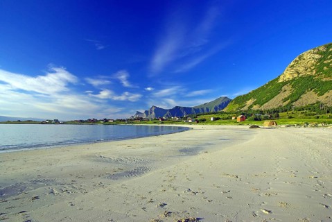 White sandy beach on the coast under blue sky with calming atmosphere, Ramberg, Flakstad, Nordland,