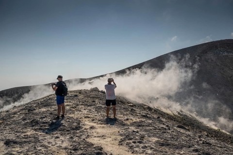 Tourists stand at the crater rim and photograph rising sulfur clouds, Vulcano, Aeolian or Lipari