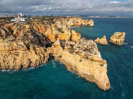 Drone view of Ponte da Piedade in Lagos, Algarve, Portugal, with ocean cliffs, sea stacks and