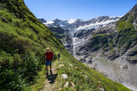 Two hikers on hiking trail, mountain landscape with Grindelwald-Fiescherfirn glacier, Bernese Alps,