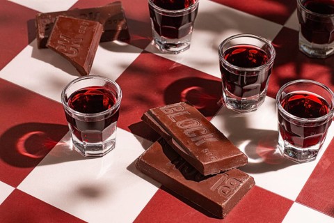 There are small glasses with a red drink on the table. chocolate liqueur, Soft light creates