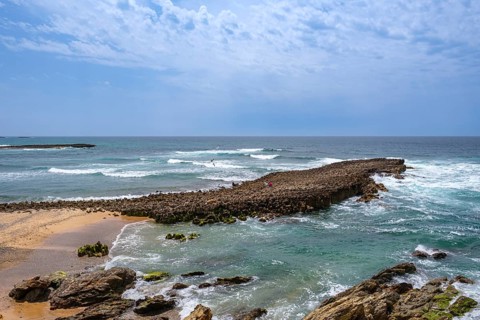 Rocky coastline with foaming waves and sweeping views of the sea, Vila Nova de Milfontes, Beja,