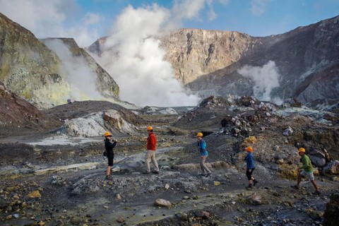 Tourists exploring the steaming volcanic crater floor of Whakaari, White Island, New Zealand