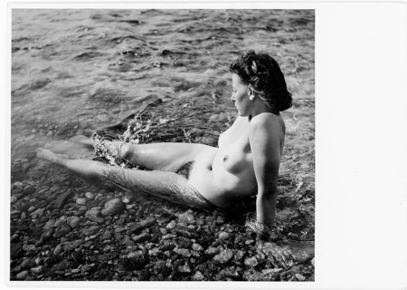 Bathing, nude photography, grace, beauty, woman sitting in shallow water on stones, enjoying the