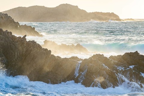 Braking waves at the coastline of Marinedda Coast at sunset, Sardinia, Italy