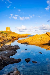 An old tower at the coast at Marinedda at sunset, Sardinia, Italy
