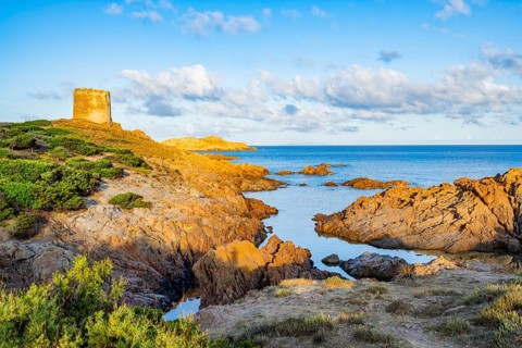 An old tower at the coast at Marinedda at sunset, Sardinia, Italy