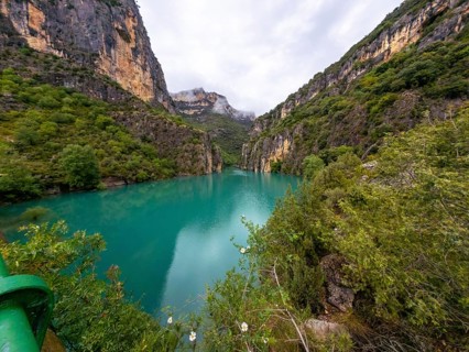 Entremon gorge revealing dramatic limestone cliffs covered in lush green vegetation descending to