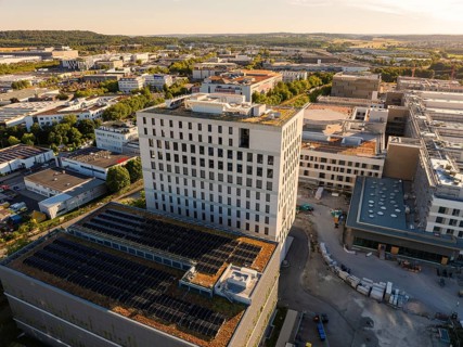 Modern buildings with solar panels on the roofs, surrounded by urban infrastructure and