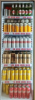 Beverage refrigerator filled with various types of beer in cans and bottles in a shop, Montenegro