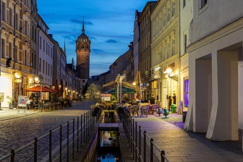 Schlossstraße in the evening with castle church tower and Röhrwasser, Luther city Wittenberg,