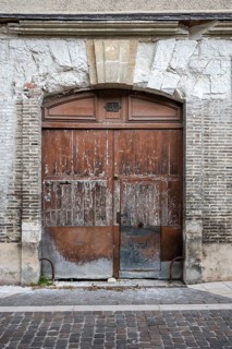 Old, weathered wooden door with weathered stone arch in the old town of Troyes, Aube department,