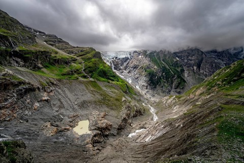 Dramatic mountain landscape covered in clouds with Grindelwald-Fiescherfirn glacier, Bernese Alps,