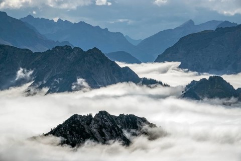 View from the Nebelhorn summit to mountains of the Allgäu Alps, mountains rising from fog in the