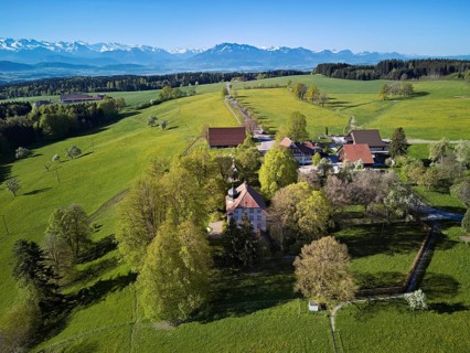 Horben viewpoint with castle and restaurant, snow-capped Alps and Mount Pilatus in the back,