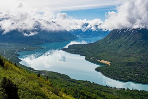 View of snowy mountains in spring and turquoise Kenai Lake with reflection, Slaughter Ridge Trail,