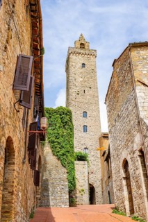 Tower of the old town with historic buildings at San Gimignano on a sunny day, Tuscany, UNESCO