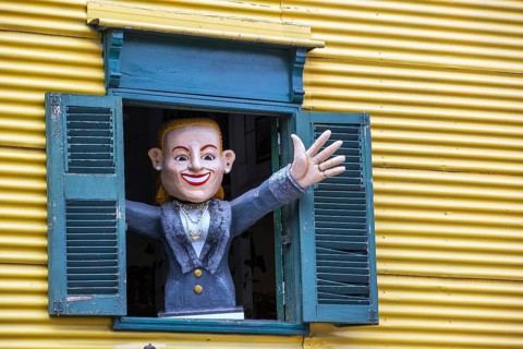 Painted figure waving from a shuttered window, La Boca, Buenos Aires, Argentina
