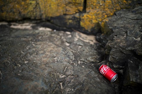 Environmental pollution, empty cola can, Coca Cola, lying on the beach between the rocks, Marazion,